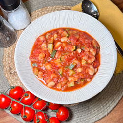 Hausgemachter Tomaten-Bohnen-Eintopf mit weißen Bohnen, Zucchini und frischen Tomaten in einer aromatischen Soße.