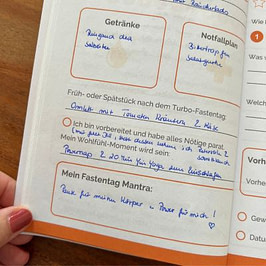 Mein Journal zum Turbo-Fastentag Seite eines Fasten-Journals mit handschriftlichen Einträgen zu Getränken, Notfallplan, Mahlzeit nach dem Turbo-Fastentag, Vorbereitung, Wohlfühl-Moment und einem motivierenden Fastentag-Mantra.