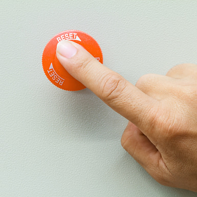 astentag-reset-koerper-symbolbild-mobile-version Ein Finger drückt auf einen roten Reset-Knopf – Symbolbild für den Fastentag als Neustart für den Körper