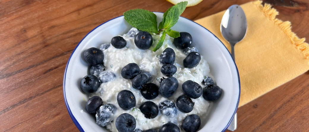 Proteinreiches Frühstück: Eine erfrischende Kombination aus Blaubeeren und cremigem Hüttenkäse, verfeinert mit frischer Minze.